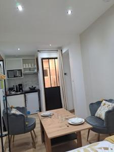 ein Wohnzimmer mit Tisch und Stühlen und eine Küche in der Unterkunft Sweet / Circuit 24h / Moto GP / Antares / Oasis - centre des expositions / Boulerie Jump in Le Mans + 11 Fotos