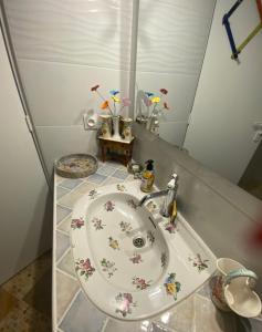 a bathroom with a sink with flowers on it at Chez Moon centre ville historique in Vernon +2 photos