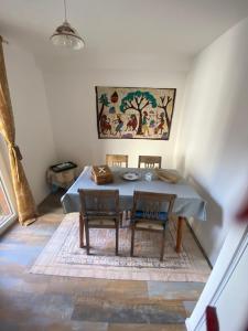a dining room with a table and chairs and a painting at Chez Moon centre ville historique in Vernon