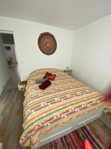 a bedroom with a bed with a blanket on it at Chez Moon centre ville historique in Vernon