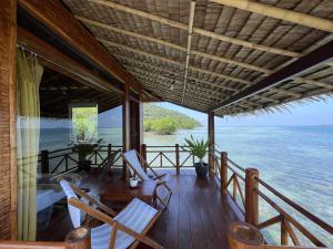 een veranda met stoelen en uitzicht op het water bij Floating Paradise in Karimunjawa