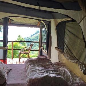 um quarto com uma cama numa tenda com uma janela em Back To Nature em Pokhara