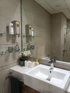 a bathroom with a white sink and a mirror at Luxury Staycation Studio in Royal Neighbourhood in Dubai