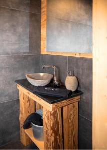 a bathroom with a bowl sink on a counter at Holzfäller-Chalet in Obdach