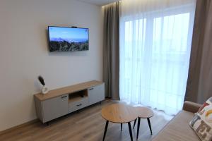 een woonkamer met een tv aan de muur bij Warmzy Home - Modern 2 Rooms Apartment With Free Parking in Vilnius