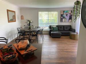 a living room with a couch and a table and chairs at On the Park-Modern 4 Bedroom -3 Living Area Home 100m to Parks and Shopping Centre in Dubbo
