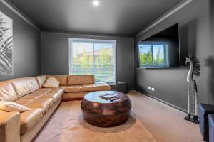a living room with a couch and a coffee table at On the Park-Modern 4 Bedroom -3 Living Area Home 100m to Parks and Shopping Centre in Dubbo