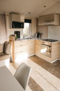 a kitchen with wooden cabinets and a stove top oven at Magnolia - Camping Belle-Vue in Berdorf