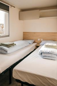 two beds sitting in a room with a window at Magnolia - Camping Belle-Vue in Berdorf