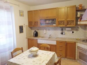 a kitchen with a table with chairs and a counter top at Villetta con parco vicino San Gimignano in Le Grazie