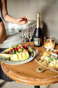 a table with a plate of fruit and a bottle of wine at Golden Golem hotel & Spa in Prague