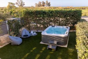 a hot tub sitting on the grass in a backyard at Ros Solis Luxure House in Chania