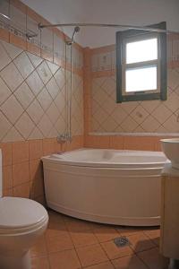 y baño con bañera, aseo y lavamanos. en Villa Christina, en Armenistis