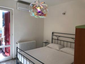 Schlafzimmer mit einem Bett und einem Kronleuchter in der Unterkunft Appartamento La Pineta in Marina di Cecina