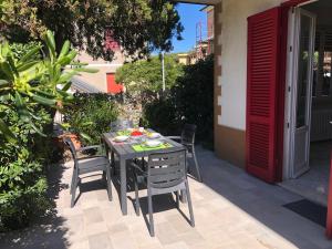 einen Tisch und Stühle auf einer Terrasse in der Unterkunft Appartamento La Pineta in Marina di Cecina