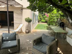 um pátio com 2 sofás, uma mesa e cadeiras em Maison Provençale à Eguilles em Éguilles