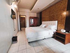 a bedroom with a white bed and a television at Panda House Chiang Mai in Chiang Mai