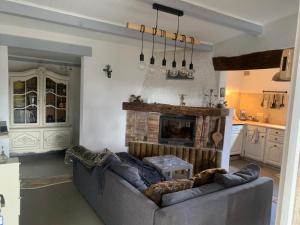 uma sala de estar com um sofá e uma lareira em MAISON AU COEUR DU VERDON em La Verdière