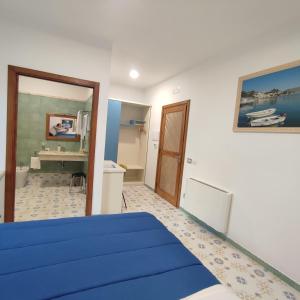una camera con letto blu e bagno di Il Barbacane a Bacoli