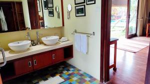 baño con 2 lavabos y espejo grande en Villa Nirvana, en Ubud