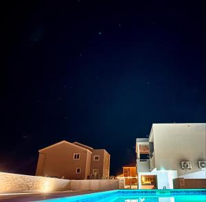 a night view of buildings and a swimming pool at Apartments ŽAJA in Seget Vranjica