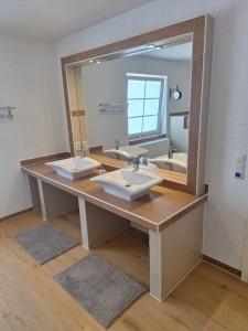 baño con 2 lavabos y espejo grande en Zur alten Scheune, en Ochtendung