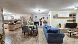 uma sala de estar com uma mesa e cadeiras azuis em B&B VILLA MARINA em Castrignano del Capo