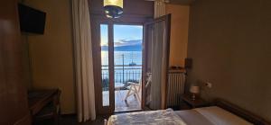 a bedroom with a large window with a view of the ocean at Hotel Garden in Torri del Benaco