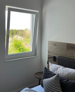 a bedroom with a window and a bed and a table at Lieblingsplatz-Bodensee in Markdorf