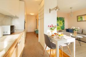 een keuken en een woonkamer met een witte tafel en stoelen bij Cosy and elegant flat with spectacular city view in Zagreb