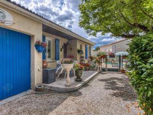 una entrada de una casa con garaje azul en Pretty house with private fenced pool, en Clarensac