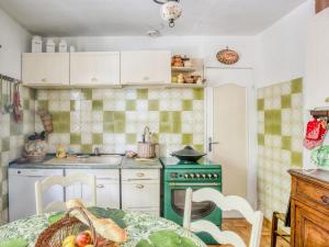 cocina con fogones verdes y mesa en Pretty house with private fenced pool, en Clarensac