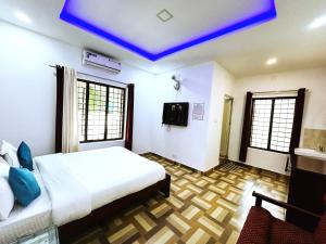 a bedroom with a bed and a blue ceiling at Deluxe Residency in Kalpetta