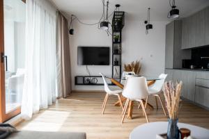 a living room with a table and chairs and a tv at Queen's Garden Balchik apartment in Balchik