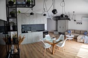 a kitchen and a living room with a table and chairs at Queen's Garden Balchik apartment in Balchik