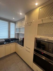 a kitchen with white cabinets and a microwave at Apartament dla Ciebie in Kętrzyn