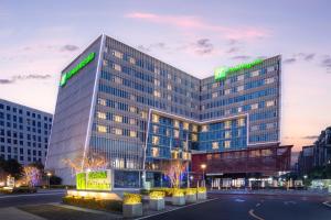 a tall building with a lit up sign on it at Holiday Inn Chengdu Airport, an IHG Hotel in Chengdu