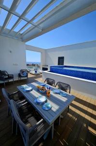 une table et des chaises bleues dans un salon dans l'établissement Heritage Paphos, luxury duplex apartment with private pool, à Paphos