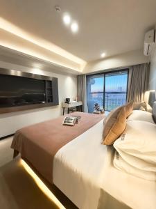 a bedroom with a large bed and a large window at Guangzhou City Inn Hotel Apartment Changgang in Guangzhou
