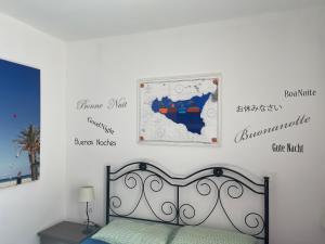 a bedroom with a bed and a map on the wall at Aurora e Andrea San Vito lo Capo in San Vito lo Capo