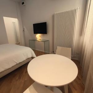 a white table in a room with a bed and a tv at Stella CasaBono in Sulmona