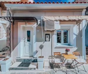 a house with a table and chairs in front of it at Dear_Jo_Guesthouse in Vathý