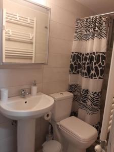een badkamer met een wastafel, een toilet en een douchegordijn bij ΗΒΗ in Athene