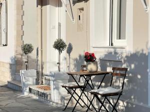 una mesa con 2 sillas y un jarrón de flores en el patio en Dear_Jo_Guesthouse, en Vathý