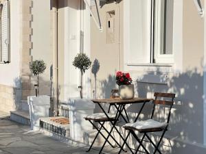 a table with two chairs and a vase of flowers on a patio at Dear_Jo_Guesthouse in Vathý