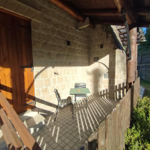 eine Terrasse mit einem Tisch und Stühlen an einer Steinmauer in der Unterkunft Il Barbacane in Bacoli
