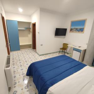 Schlafzimmer mit einem blauen Bett und einem Schreibtisch in der Unterkunft Il Barbacane in Bacoli