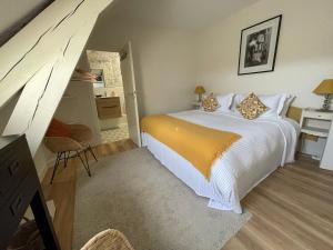 - une chambre avec un lit et une couverture jaune dans l'établissement Fonsegre Chambres d'Hôtes, à Magny-Cours
