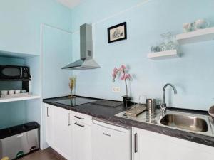 uma cozinha com armários brancos e um lavatório em Holiday Home in San Crist bal de la Laguna em La Laguna