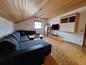 sala de estar con sofá azul y mesa en Ferienwohnung-Felisa en Peterswörth